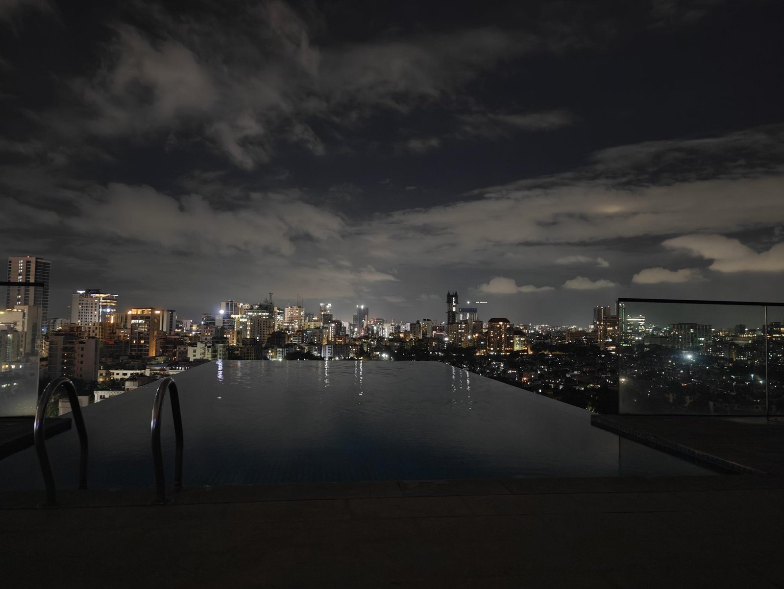 Infinity rooftop pool with city skyline night view in Dhaka